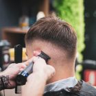 Barber trimming a man’s hair with clippers