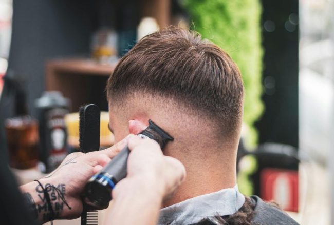Barber trimming a man’s hair with clippers