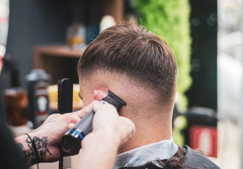 Barber trimming a man’s hair with clippers